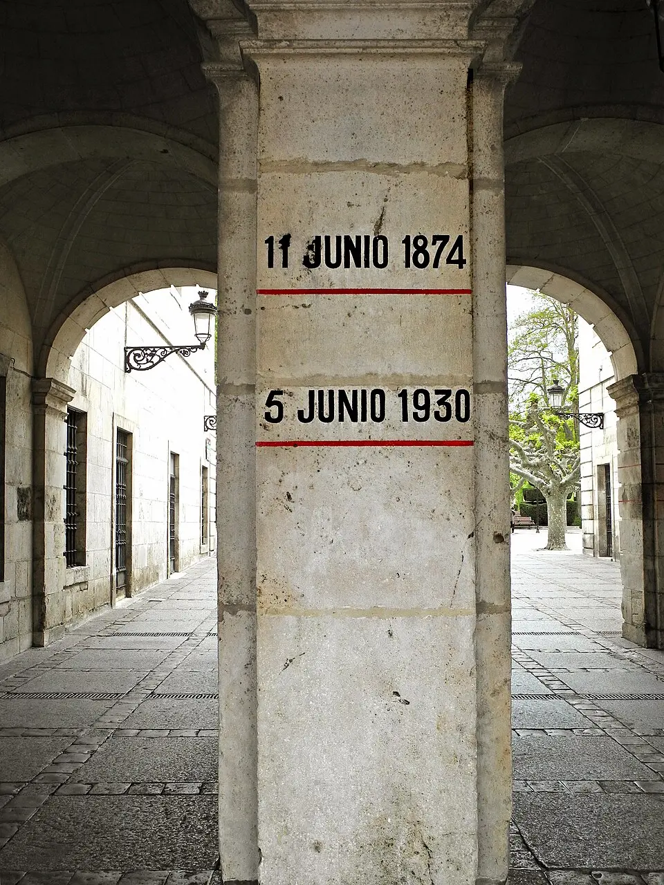 Dos marcas con fechas 11 JUNIO 1874 y 5 JUNIO 1930 en una pilastra del Ayuntamiento de Burgos, cada una sobre una línea roja que indica el nivel de la inundación.